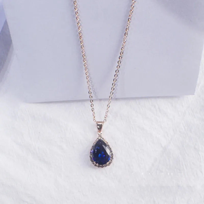 Water drop shaped geometric pendant necklace with rhinestone detailing in rose gold pink colour