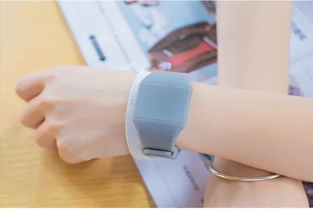 Square electronic touch screen watch with plastic case and PU strap on a wrist.