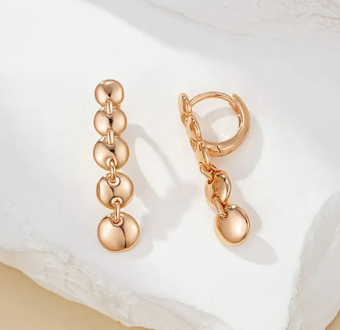 A pair of gold-coloured retro long round circle earrings with a woven copper texture.