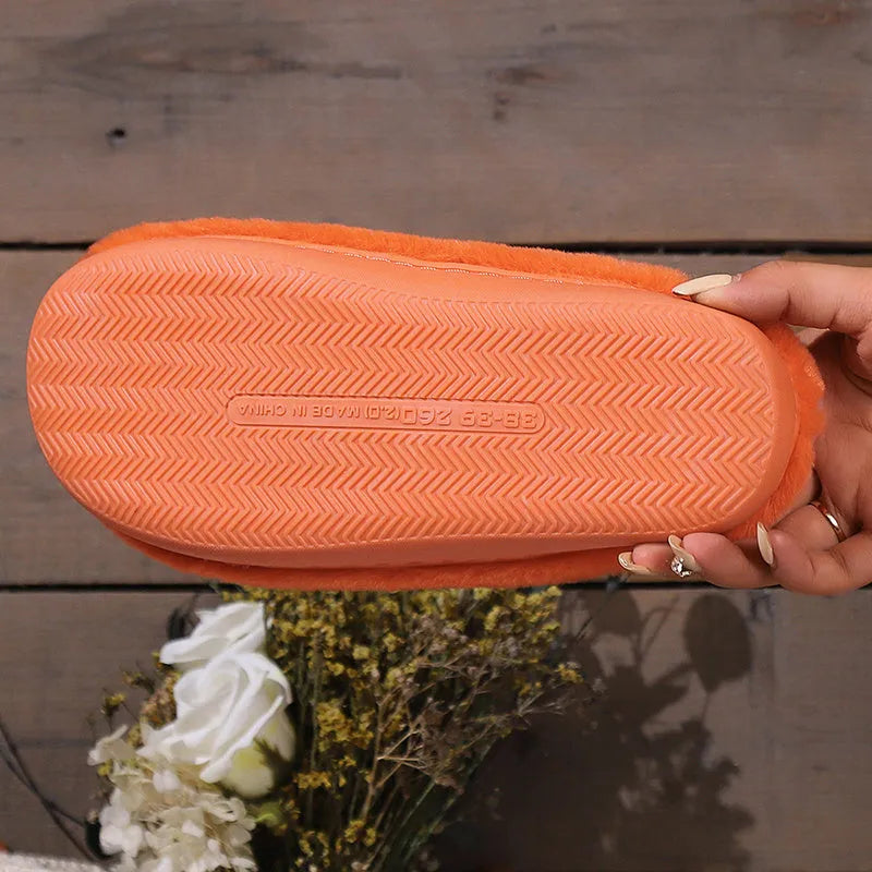 Orange Halloween pumpkin slippers with plush lining and a textured non-slip PVC sole.