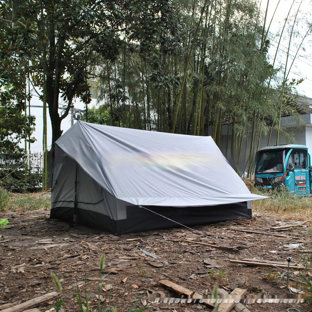 Brown A-line tent pitched with hiking poles, showing guy lines and aluminium ground nails.