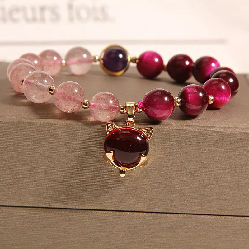 Simple women's bracelet made of transparent strawberry crystal beads on a black elastic rope.