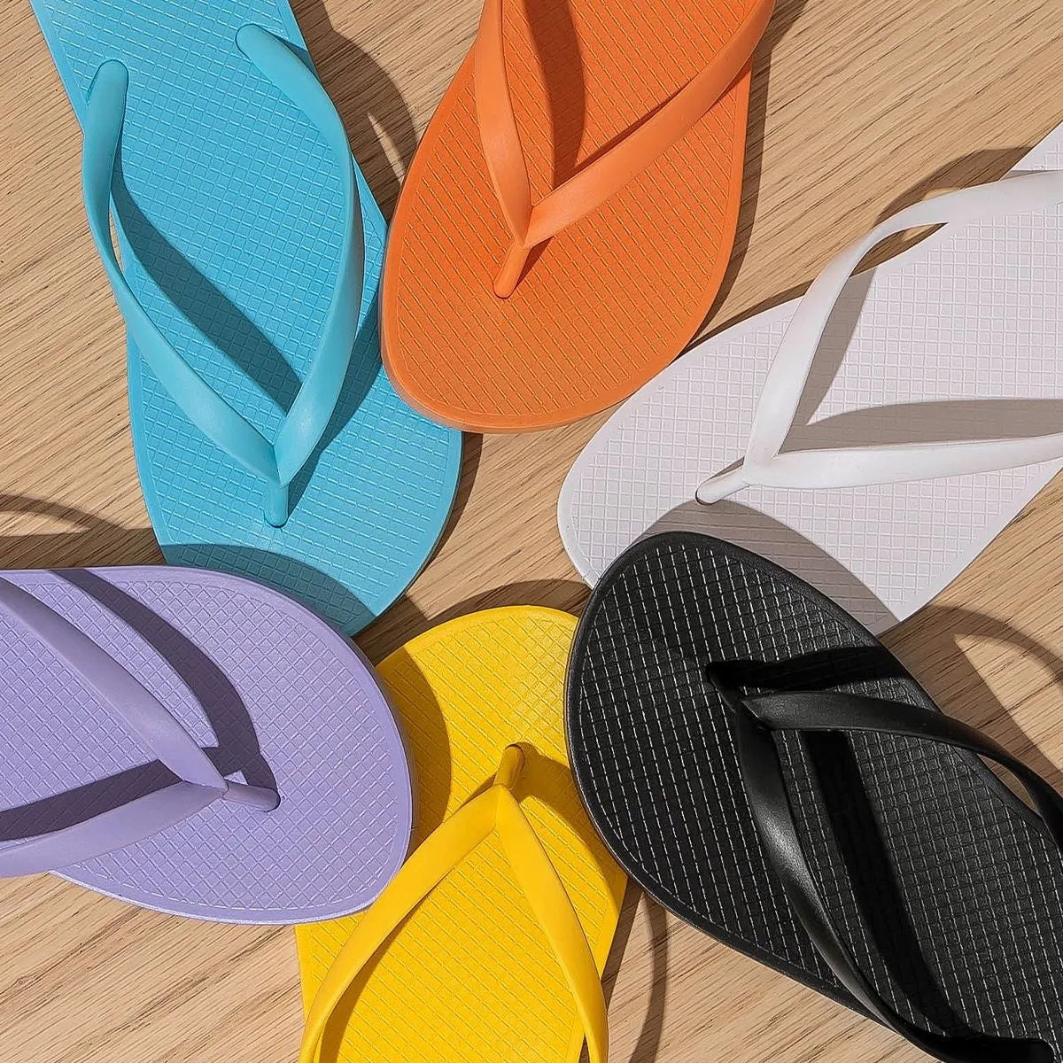 Foldable casual beach slippers in orange with hollow-out plastic upper and non-slip PVC sole.