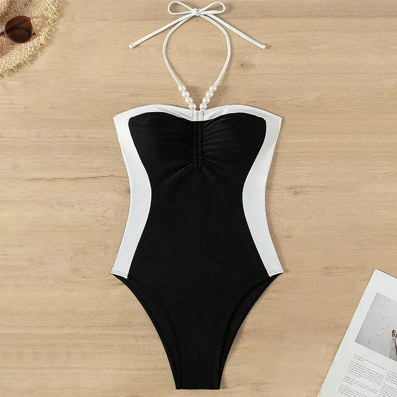 Black and white women's one-piece swimsuit with pearl spaghetti straps, sleeveless slim-fit design.