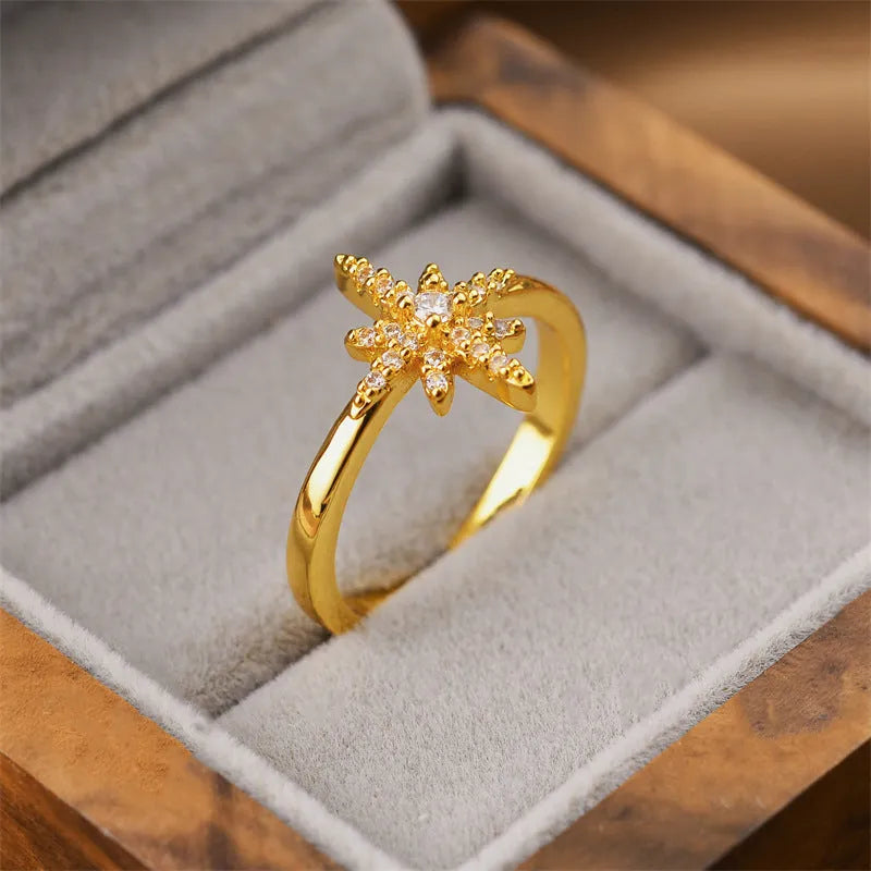 Gold geometric open-back adjustable fashion ring on a flat surface.