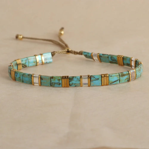 Adjustable geometric beaded bracelet with pull beads in milky white, black, green, blue or red.
