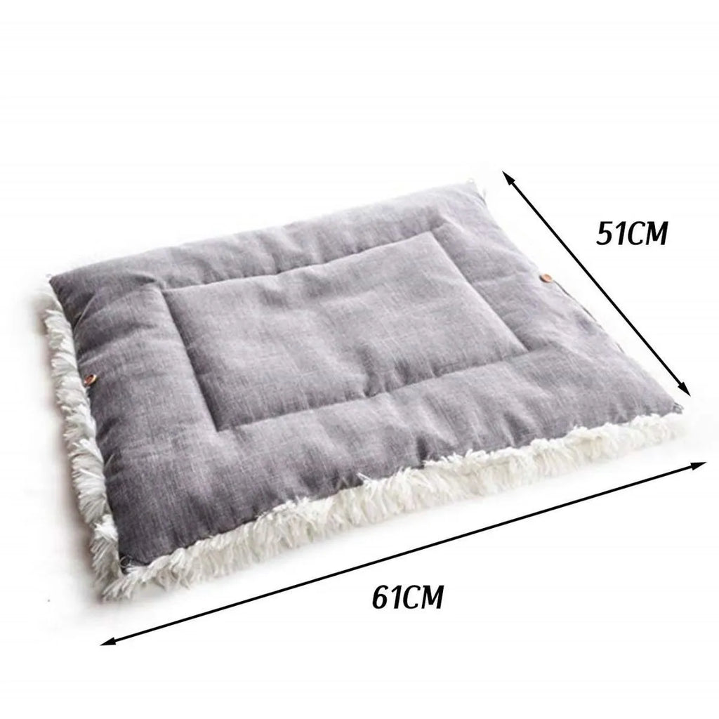 Grey fluffy pet sleeping pad for cats and dogs on a sofa, showing non-slip black bottom.