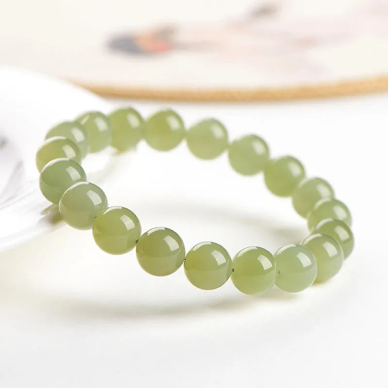 Polished Hetian jade bead bracelet in ice-like clear tones on a white background.