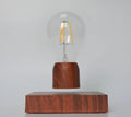 Magnetic levitation floating light bulb hovering above a wood-effect base.