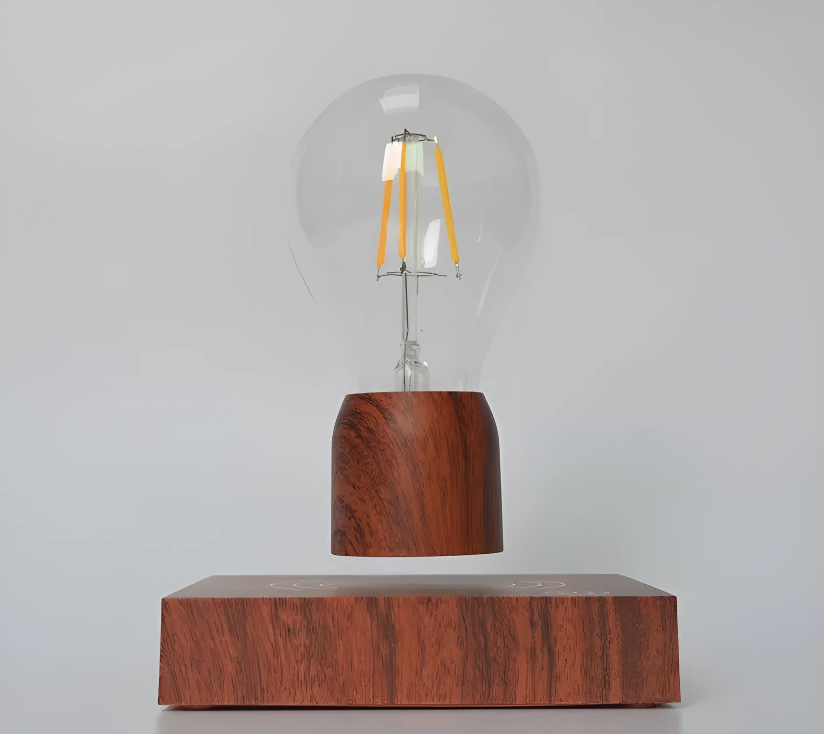 Magnetic levitation floating light bulb hovering above a wood-effect base.