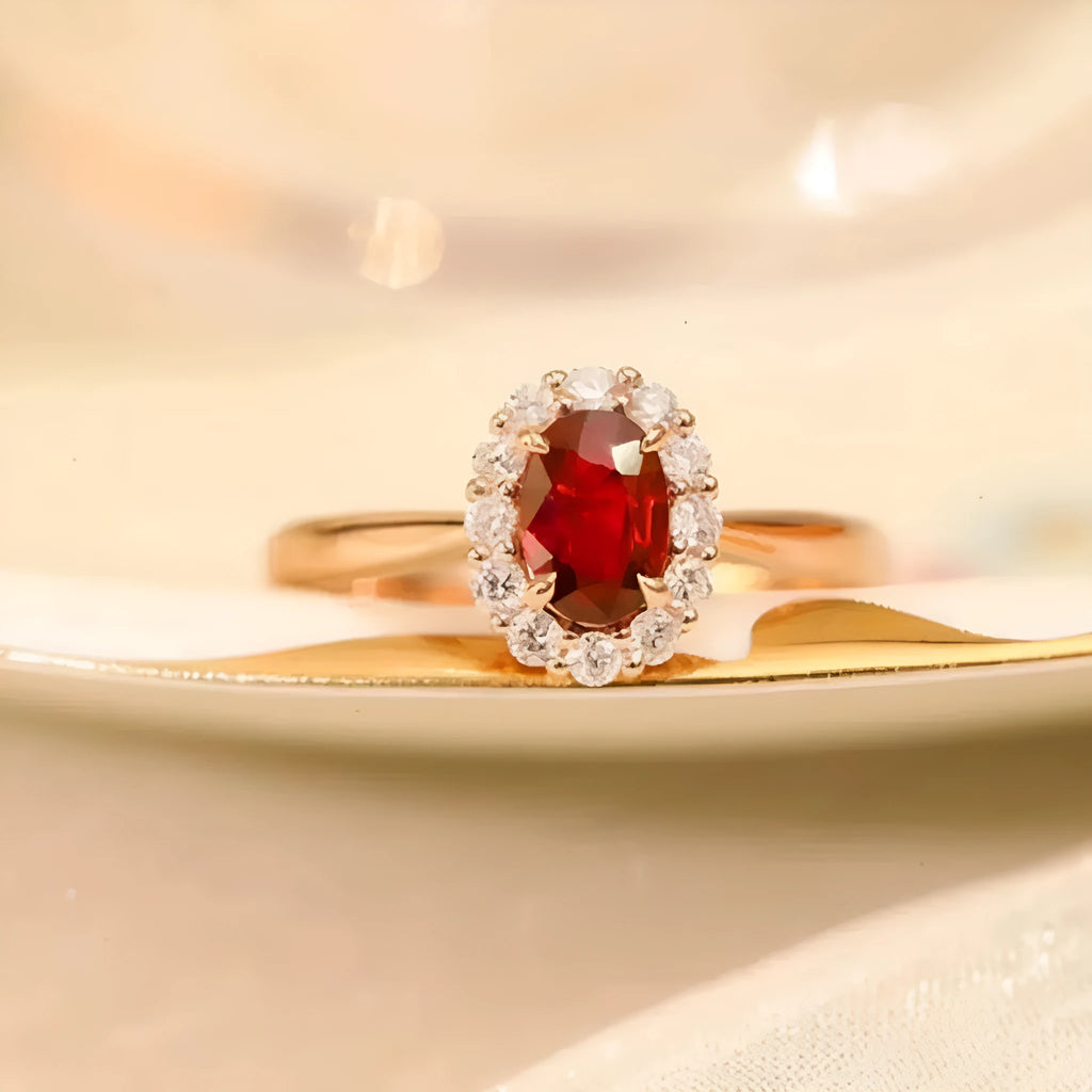 Silver plated ring with gold pigeon design and red blood gemstone inlay on a floral pattern band.