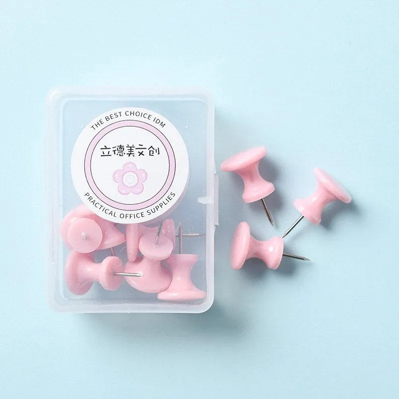 Small box containing assorted pastel pink, green, and lavender plastic push pins in two sizes.