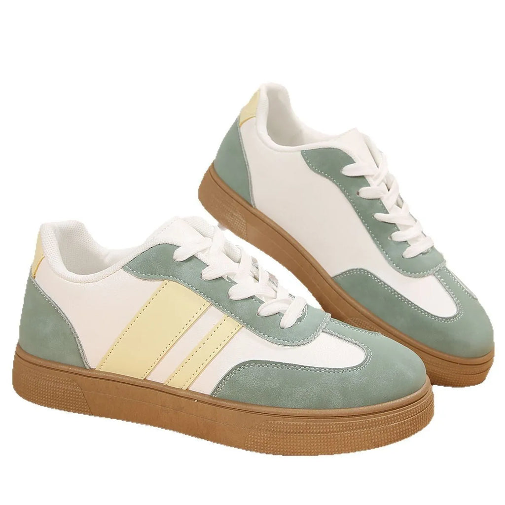 Green women's retro low-top trainers with cross-strap detail and round toe on a white background.