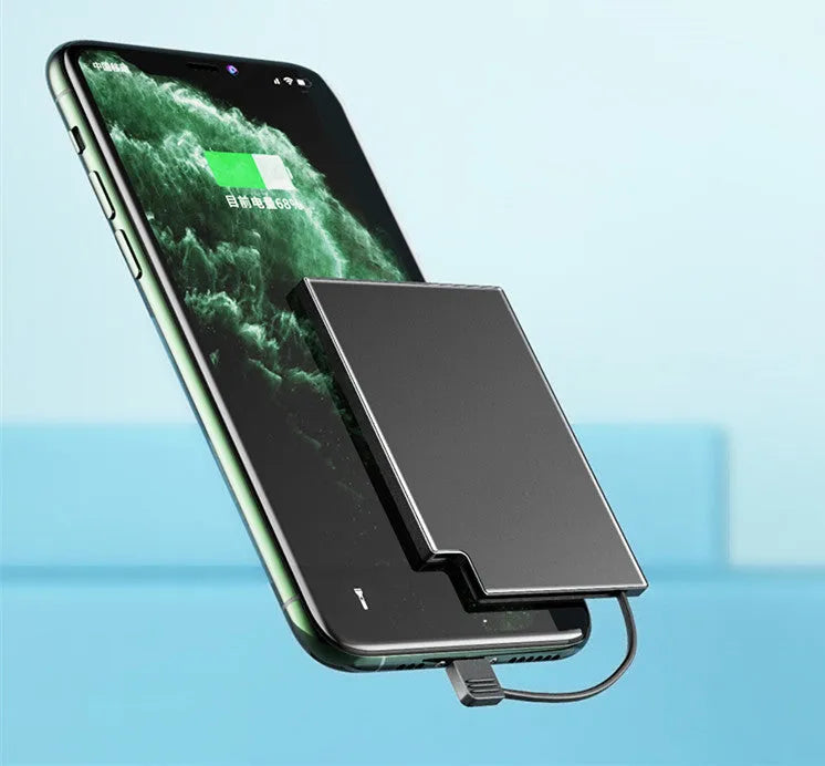 Ultra-thin black alloy card type power bank with built-in charging cable 10000mAh placed on a desk