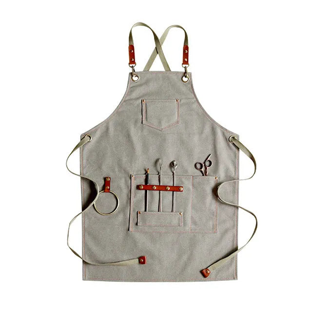 Canvas apron with cross-back straps in camel colour.