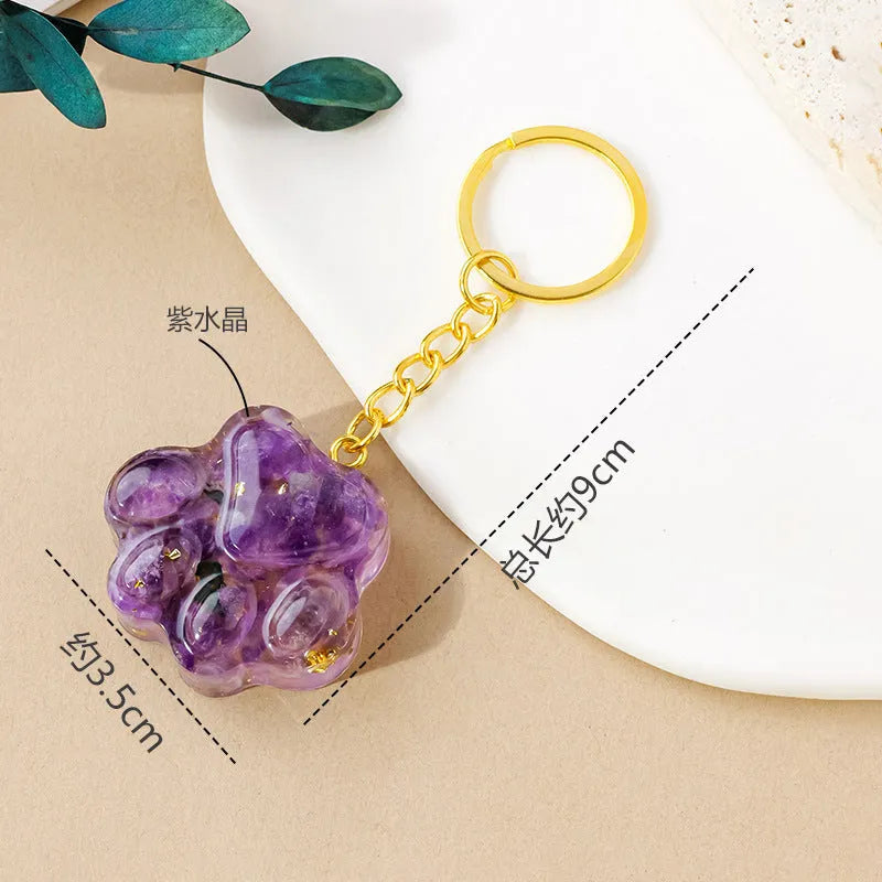 Small crystal cat's paw keychain pendant on a keyring, shown in various gemstone colour options.