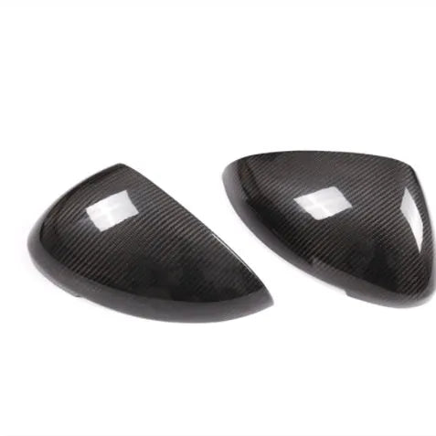 Pair of black true carbon fibre rearview mirror covers for Porsche Macan, showing textured weave pattern.