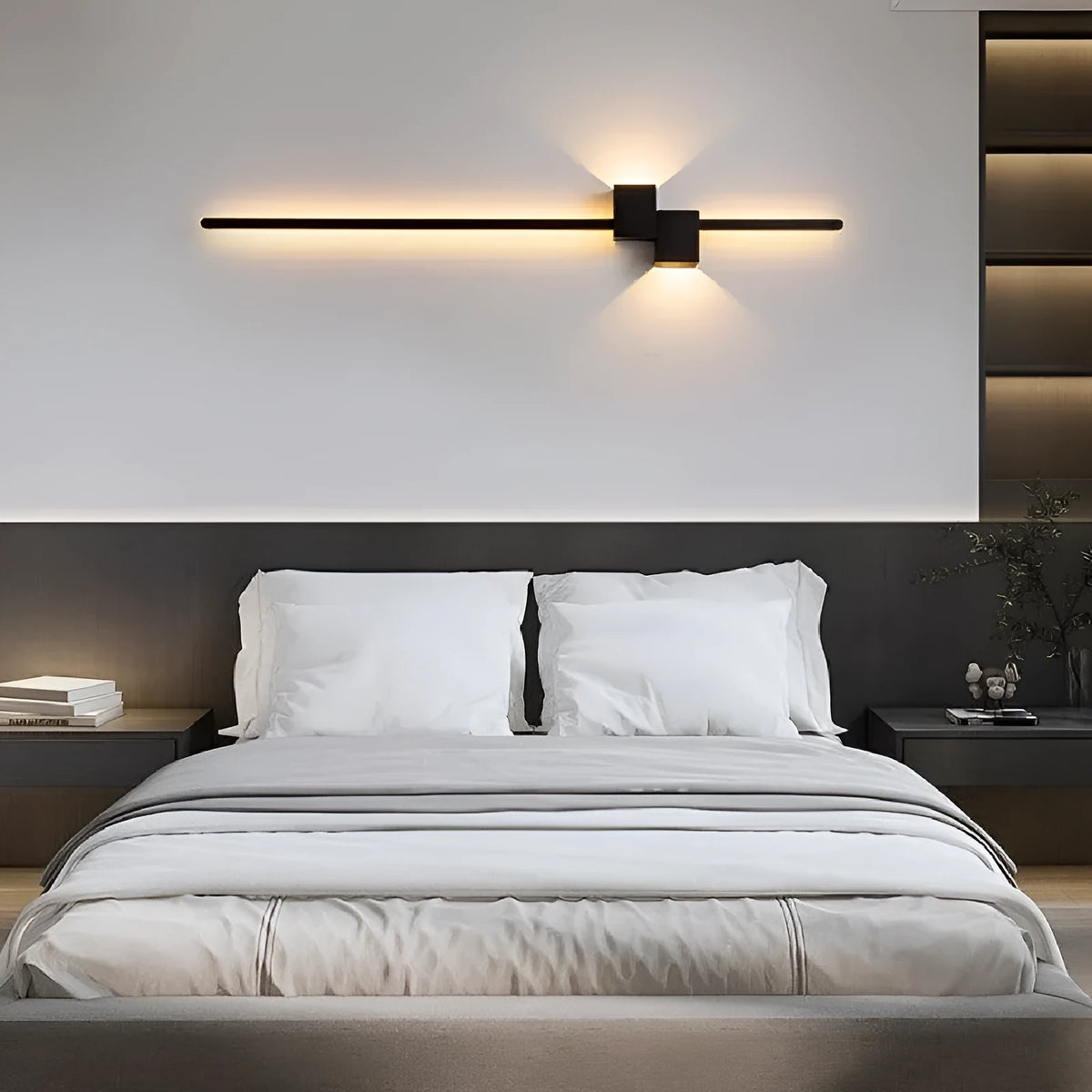 Modern minimalist wall lamp black 80cm length installed above a bedside table with warm low-voltage light