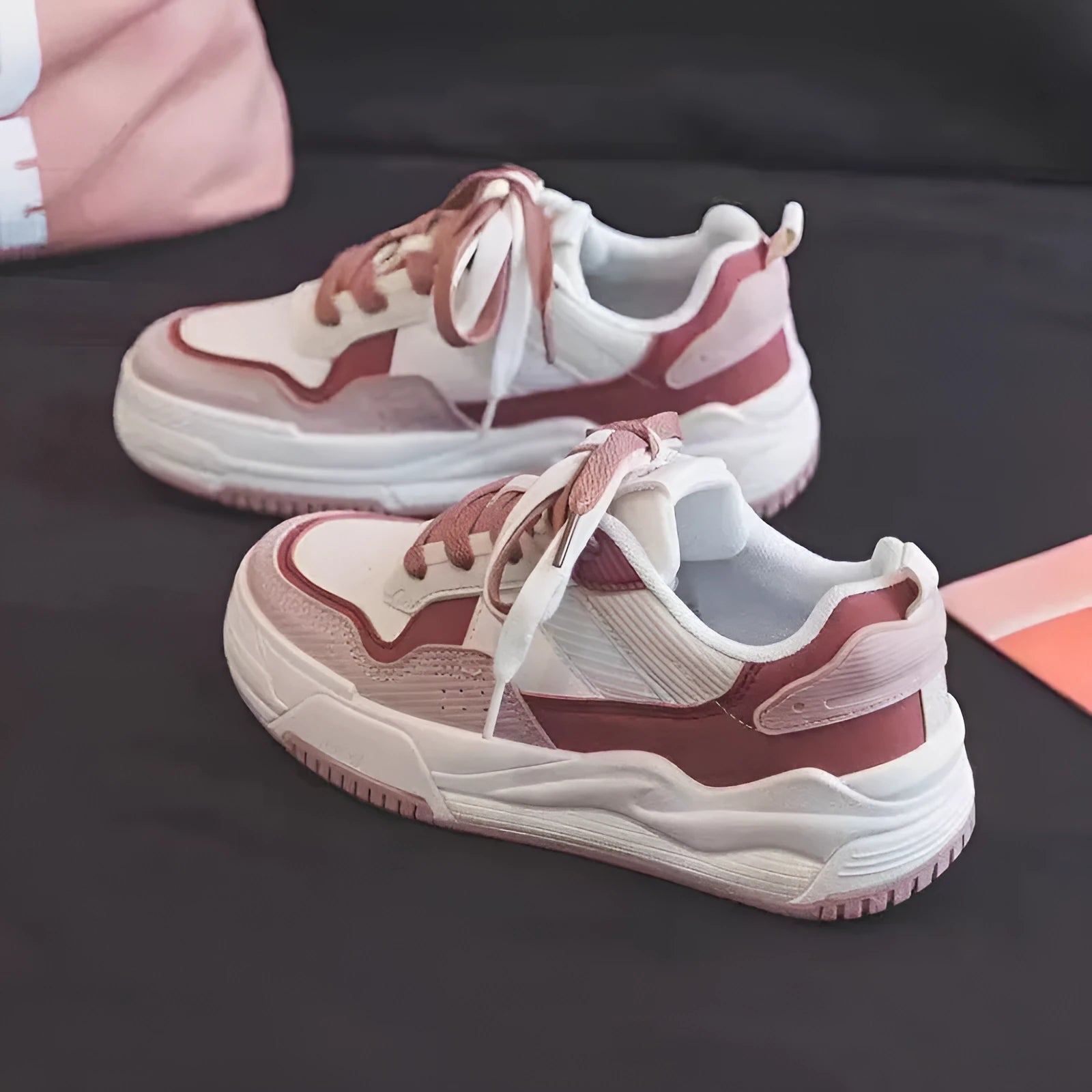 Women's pink and beige low-top sneakers with a rubber sole for height increase.