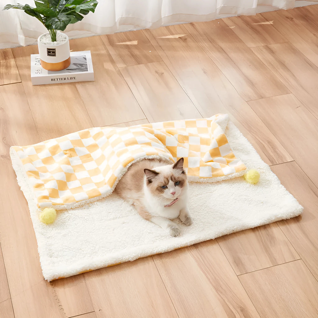 Green plaid pattern soft fleece pet blanket with fur ball decoration on a sofa