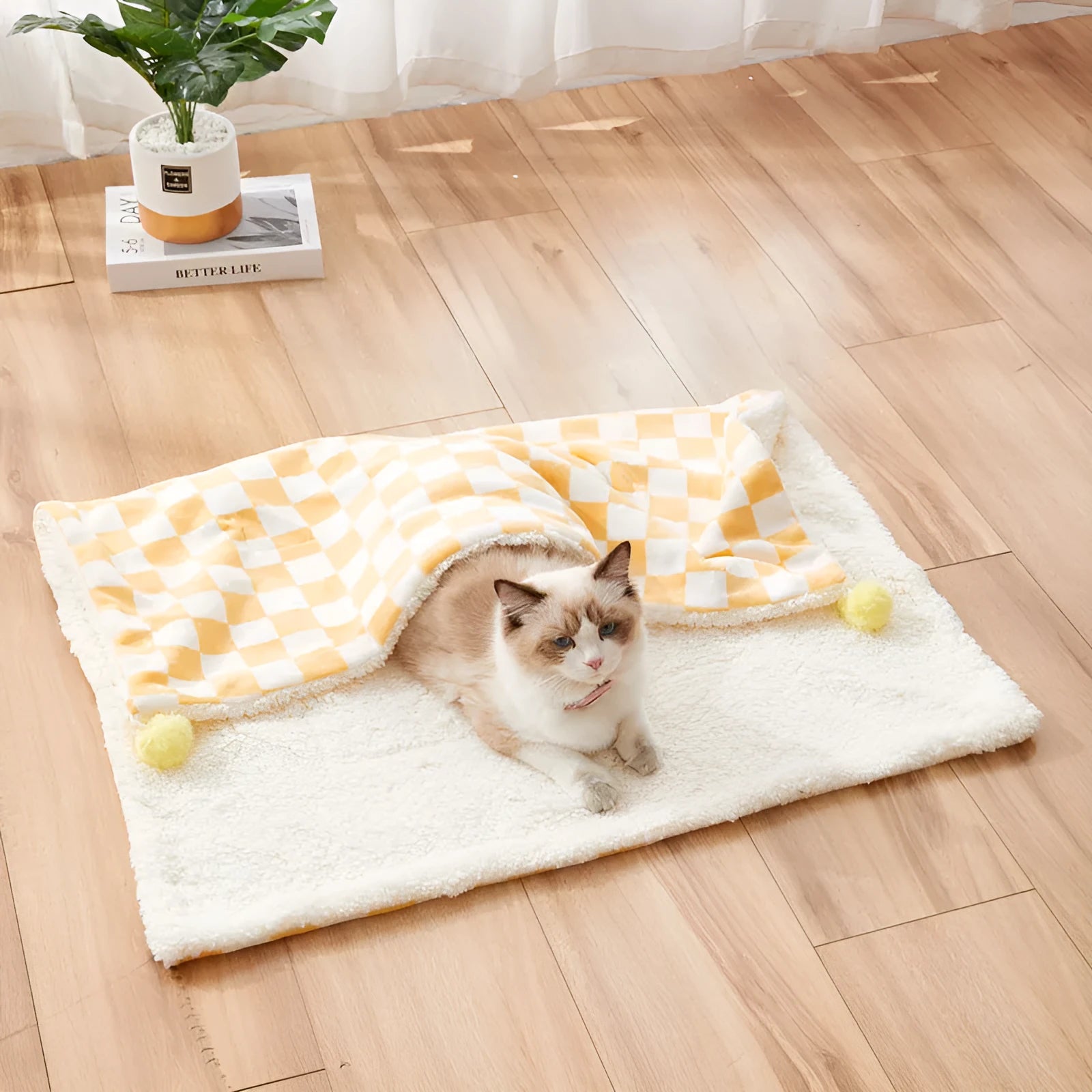 Green plaid pattern soft fleece pet blanket with fur ball decoration on a sofa