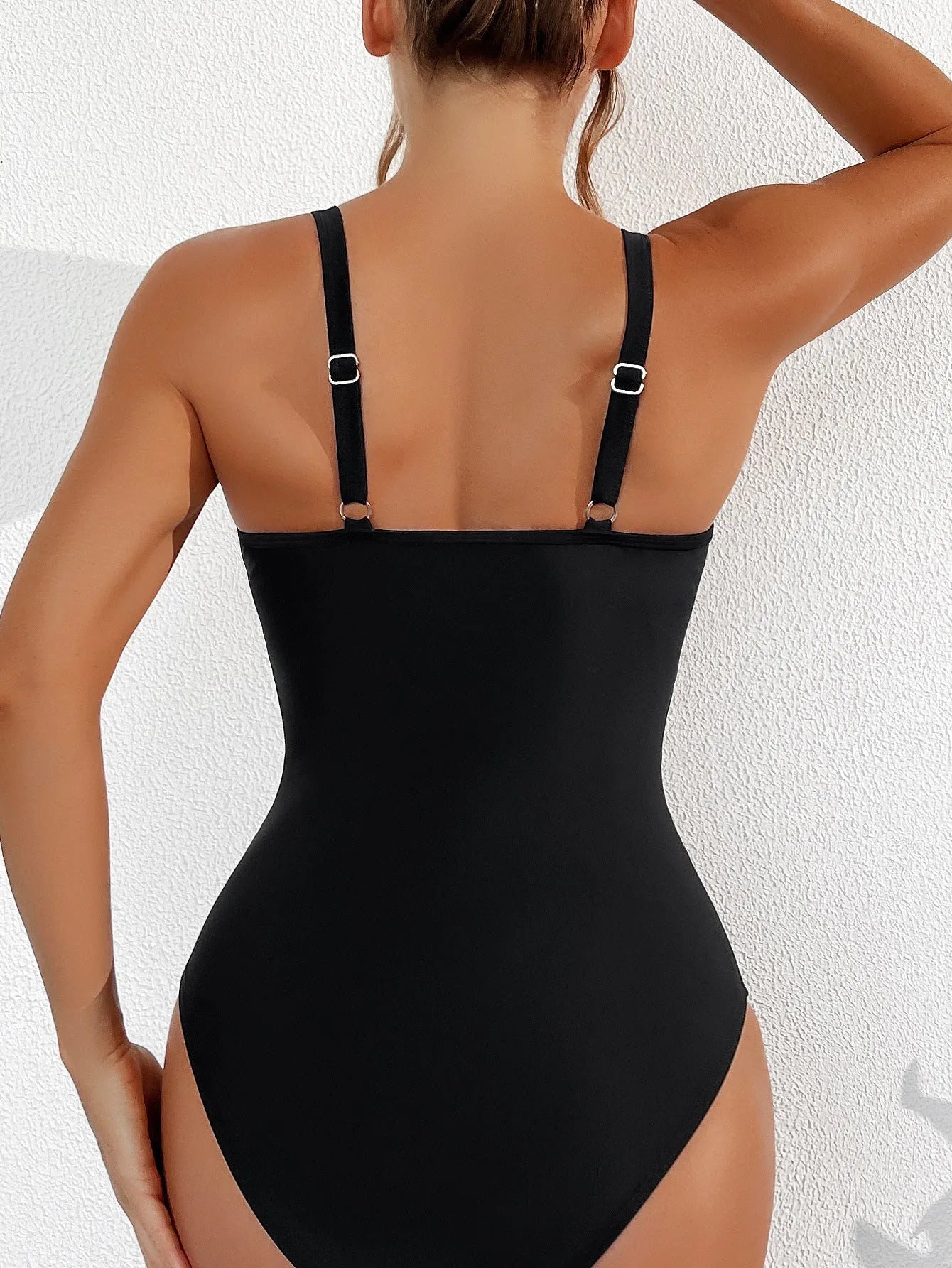 Black women's one-piece swimsuit with halter neck and briefs-style bottom made of nylon.