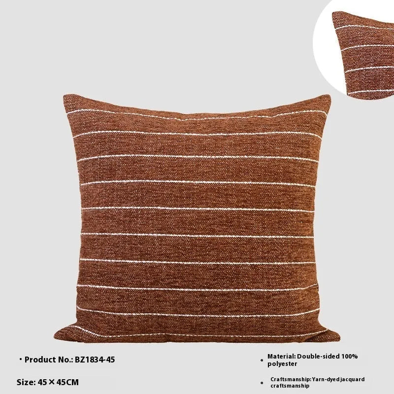 Chinese style square cushion with geometric pattern in Maillard brown colour on a sofa.