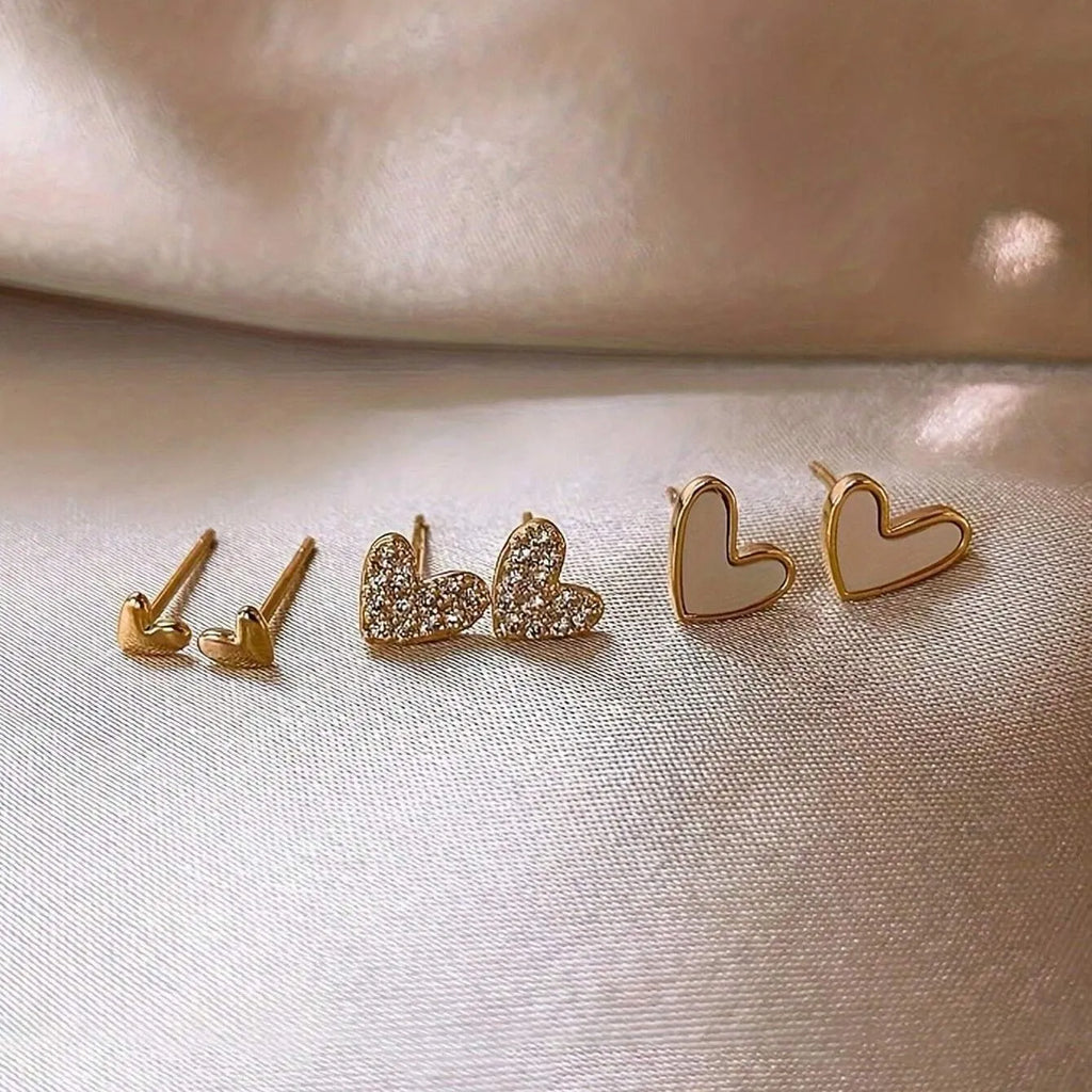 Three pairs of heart-shaped women's earrings in gold, black, and pink colour options