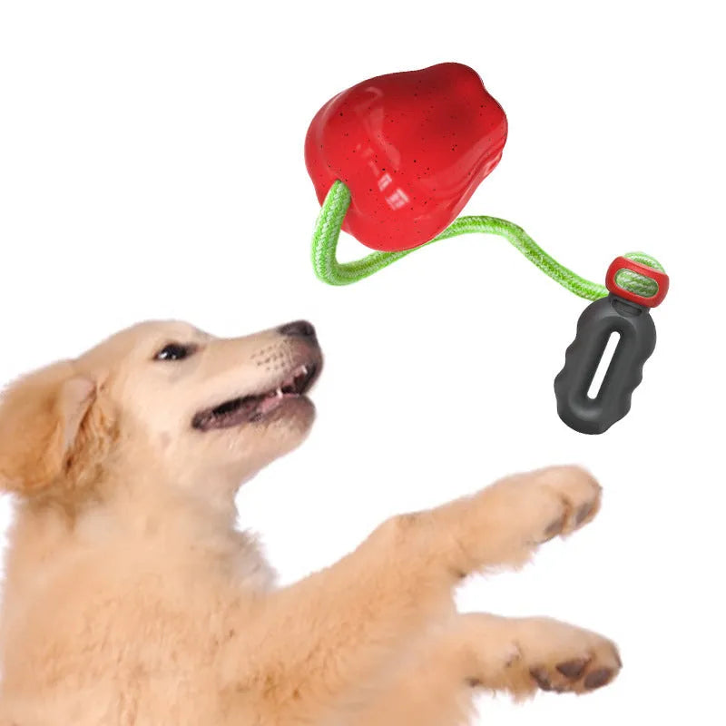 Green apple-shaped dog molar toy with dropping ball mechanism on white background