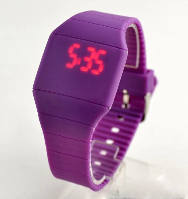 Square electronic touch screen watch with plastic case and PU strap on a wrist.