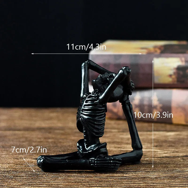 A detailed resin desktop ornament of a yoga-pose skeleton skull in black and white colour options.