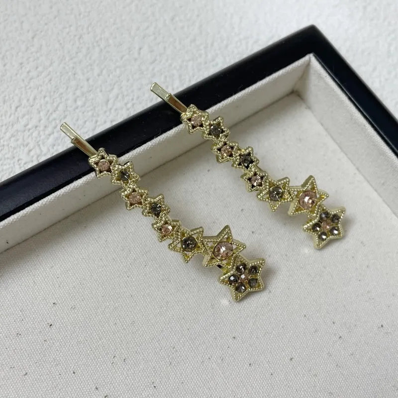 Gold-coloured Korean style hair barrette with a star and letter decoration, shown as a side clip for bangs.