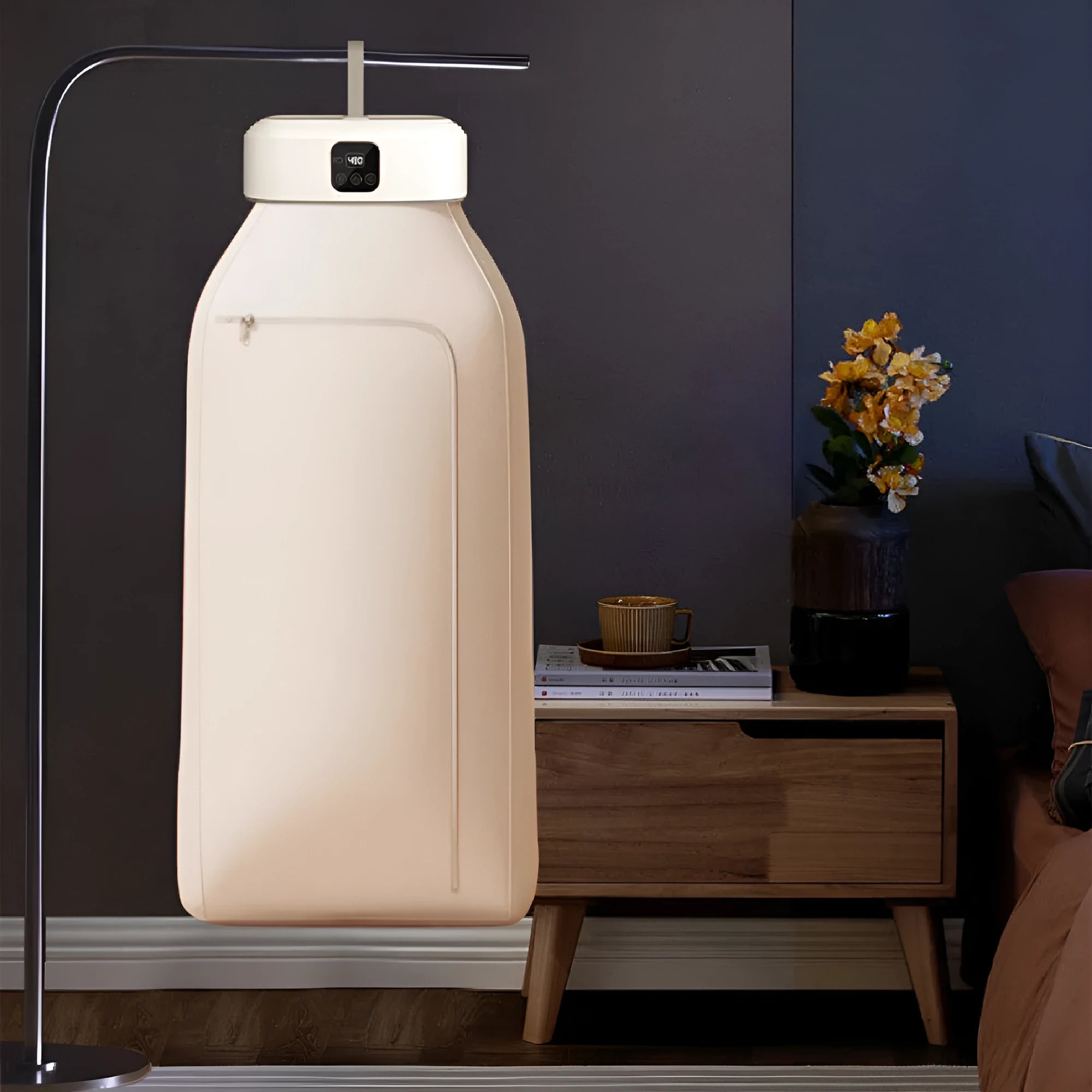 White cylindrical foldable laundry dryer with remote control on a table.