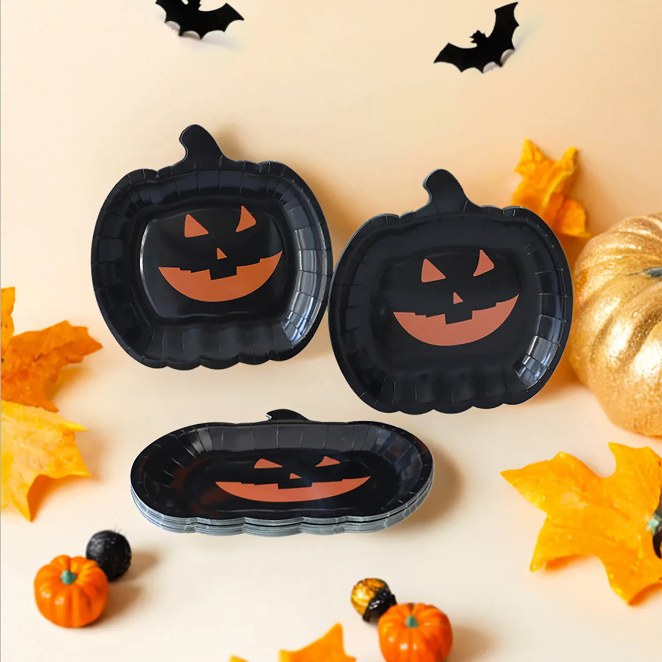 Black Halloween paper plate with pumpkin design, 9 inches in diameter.