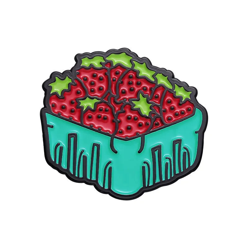 Colourful cartoon fruit design metal letter brooch on a fabric background.