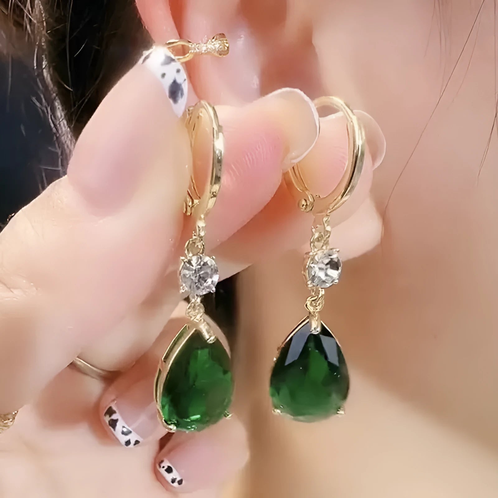 A pair of green geometric teardrop alloy earrings on a white background.