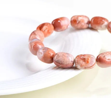Natural cherry agate bracelet with 10x14mm barrel beads and a geometric ruyi design.