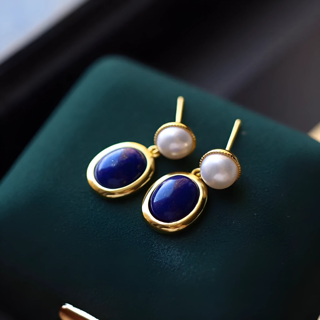 A pair of simple 925 silver stud earrings with a blue lapis lazuli pearl and auspicious patterns.
