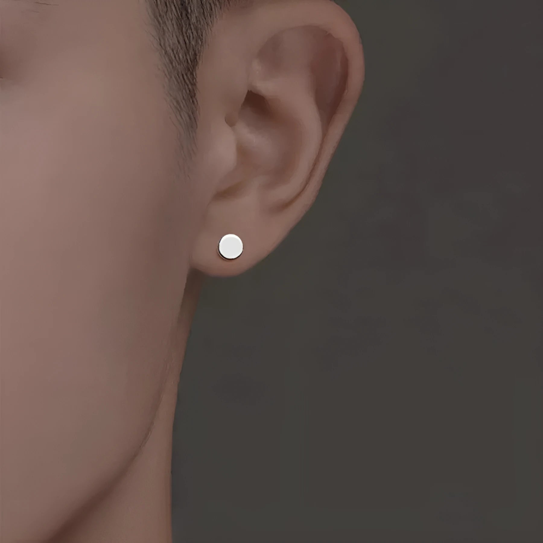 A pair of S999 sterling silver geometric round flat ear bone studs in black and silver finishes, showing size scale.