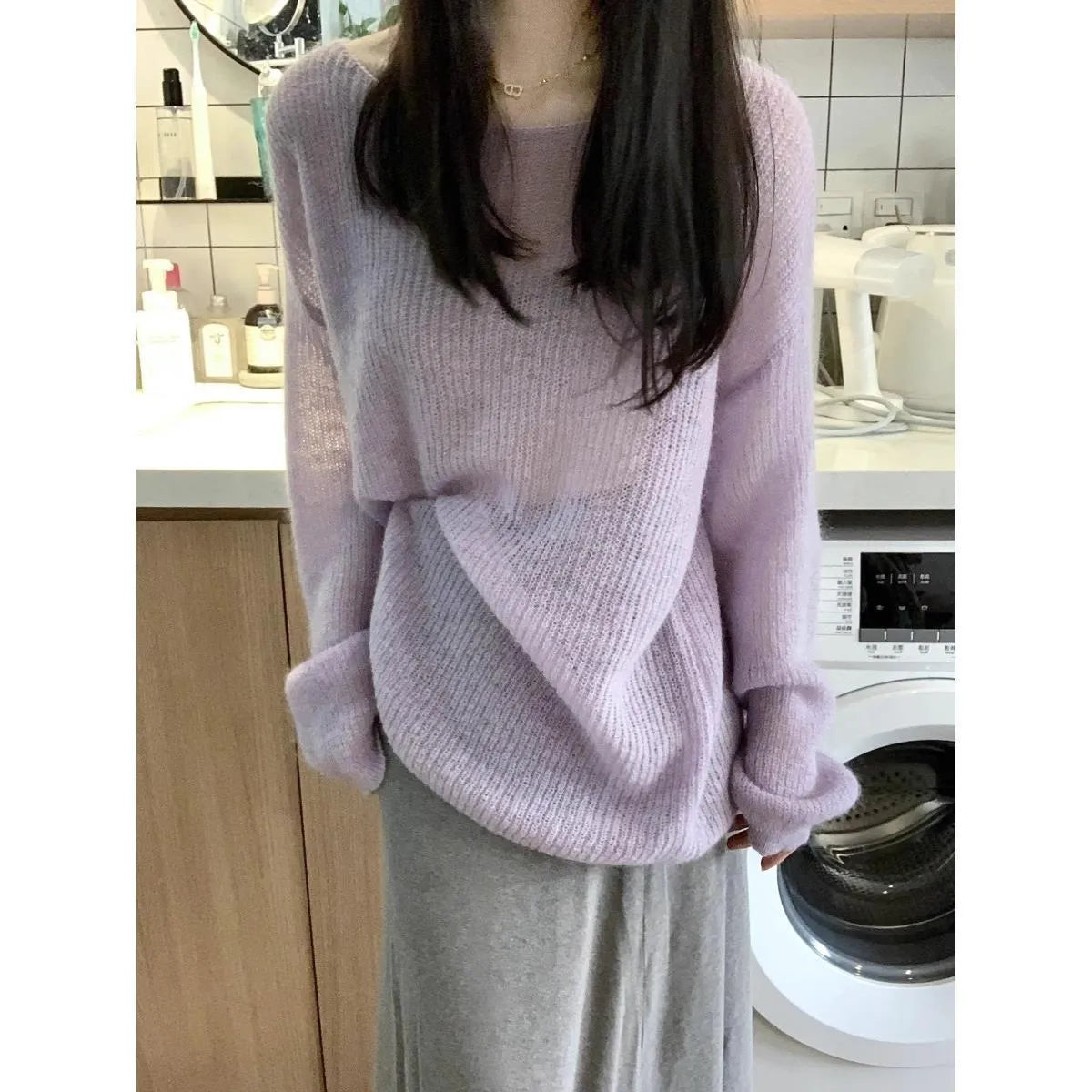 Purple women's blouse with hollow out design and sleeveless princess sleeves on a hanger.