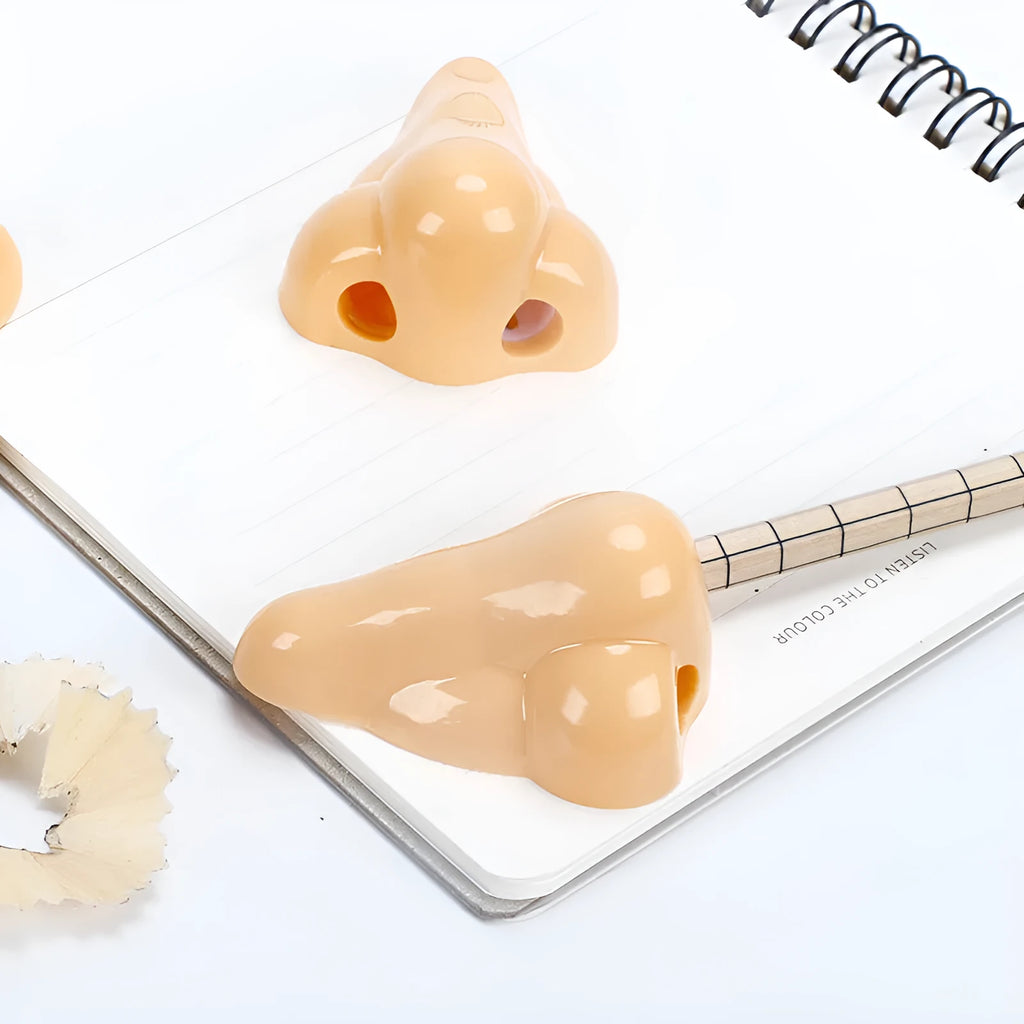 Flesh-colour plastic manual pencil sharpener with a large nostril and geometry-shaped body.