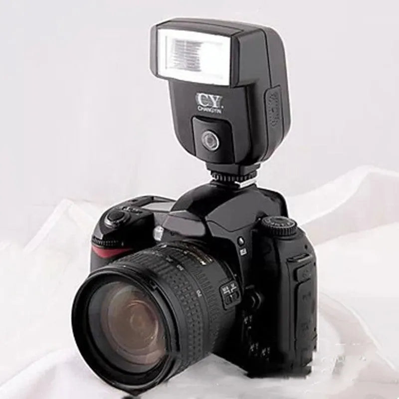 Silver SLR camera flash unit with tilt mechanism mounted on camera hot shoe