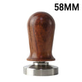 Black silicone coffee tamper pad with stainless steel base for non-slip espresso preparation.