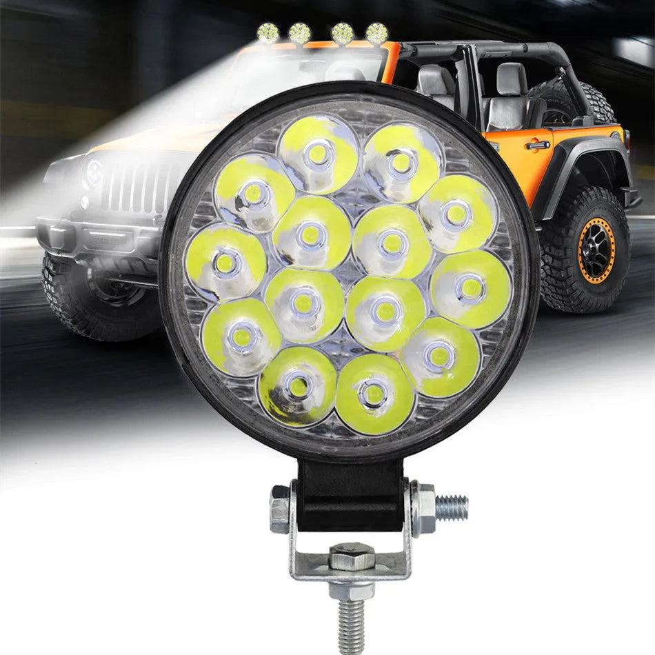Compact round white LED work light with aluminium housing for car, truck, and off-road use.