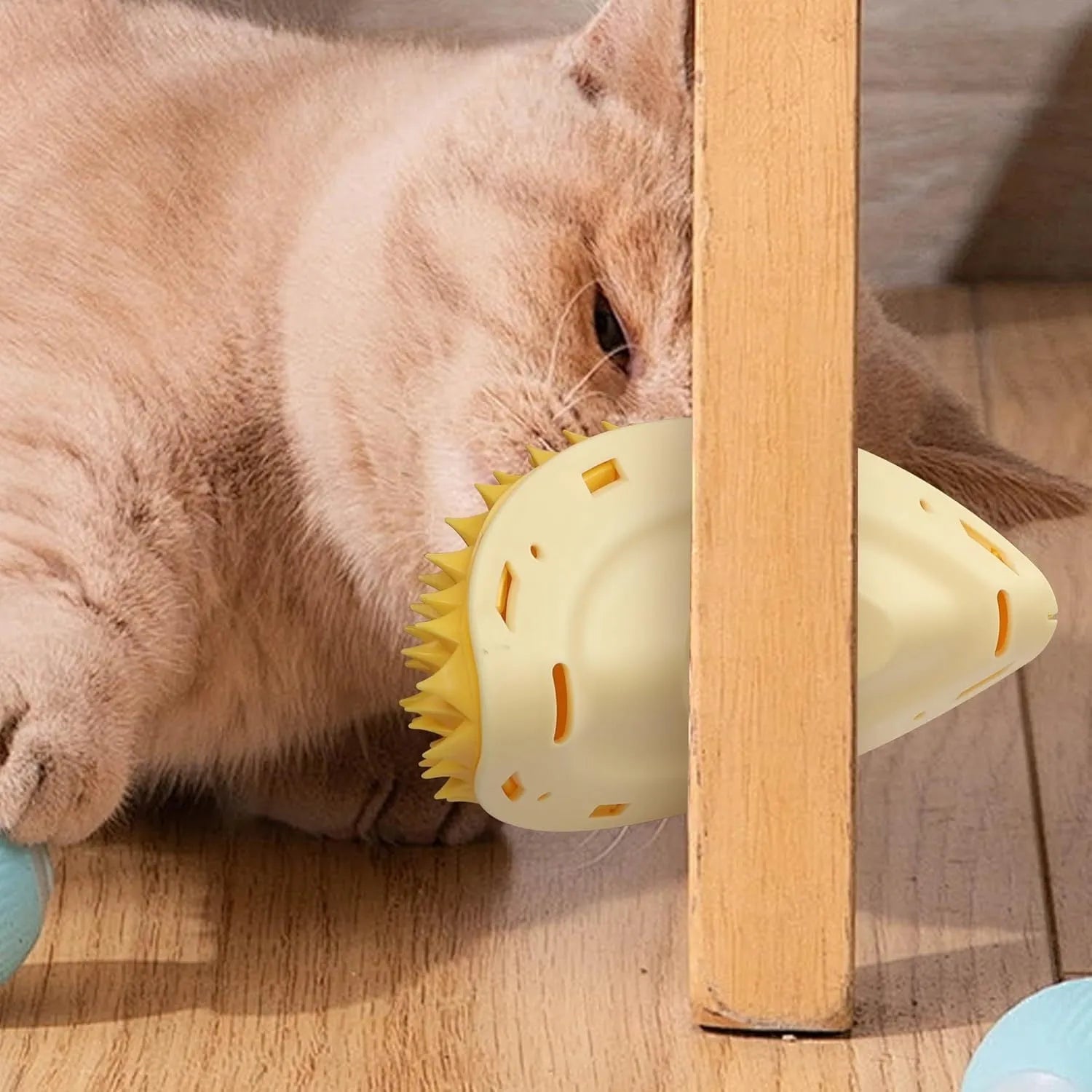 Yellow durian-shaped cat corner scratcher and grooming comb mounted on a wall corner.