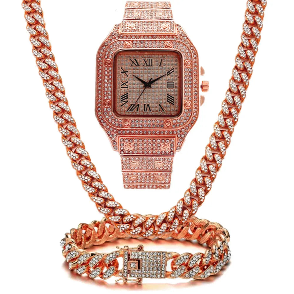 Gold Roman numeral quartz watch with diamond studs on a black mesh band, alongside a matching bracelet and necklace.