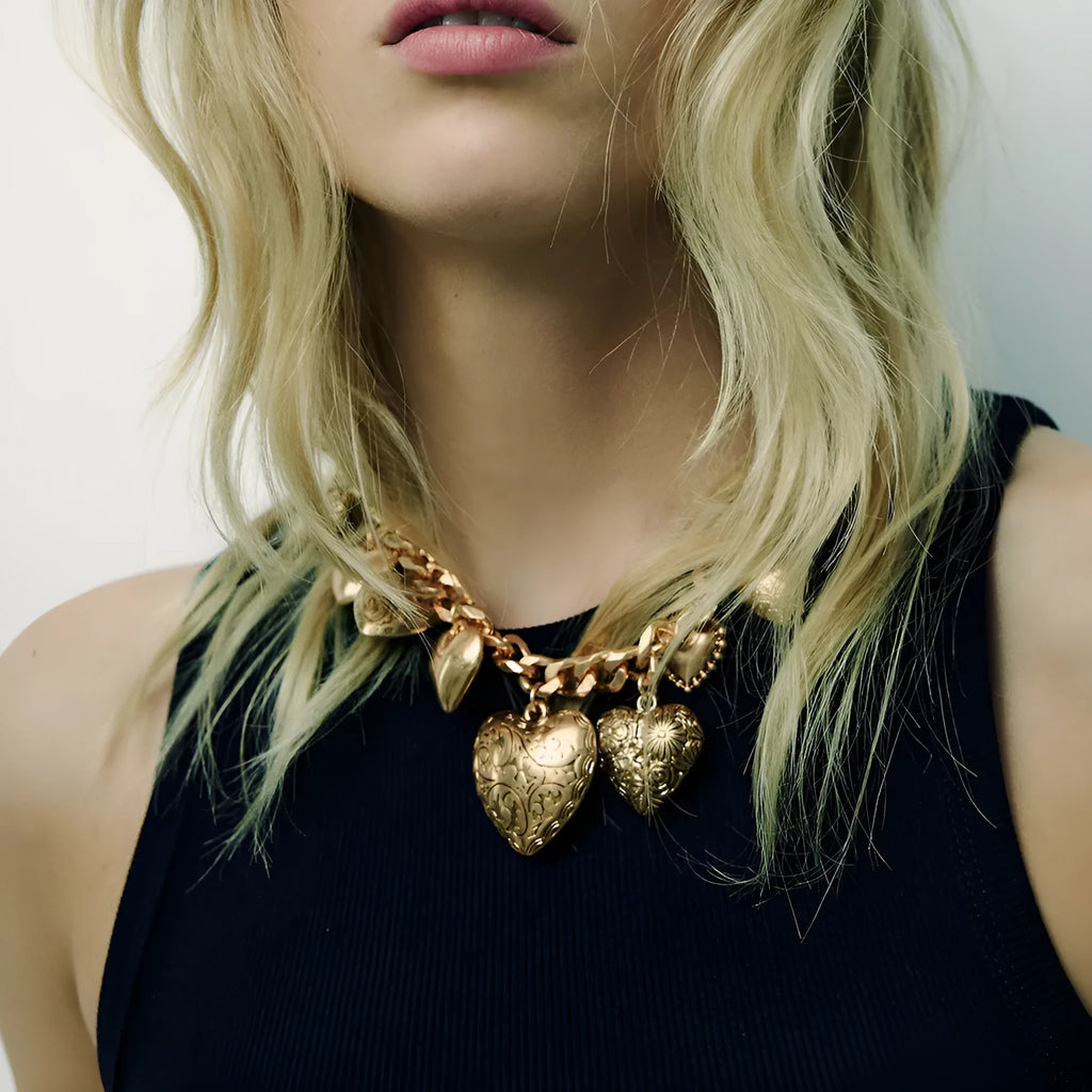 Exaggerated carved heart-shaped pendant necklace on an adjustable metal chain, shown in a gold colour finish.