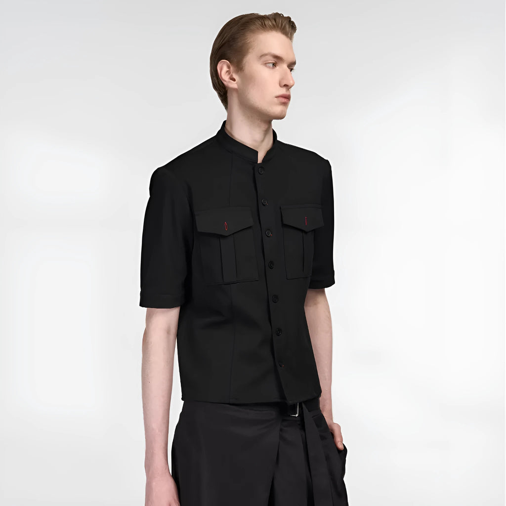 A black handmade half sleeve shirt with a shirt collar, shown on a hanger.