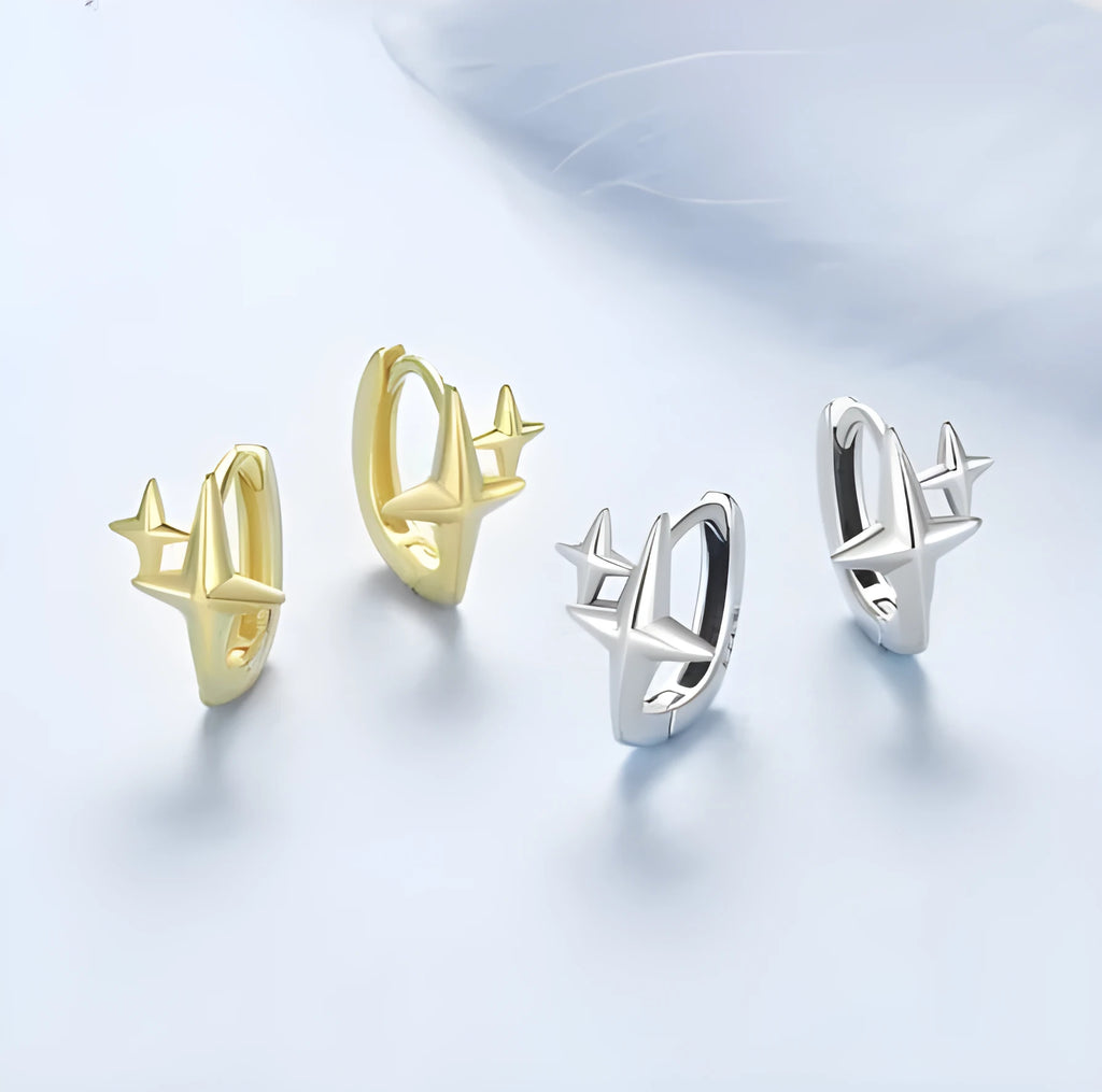 Minimalist star-shaped silver ear clips with an oxidised finish and XINGX design detail.