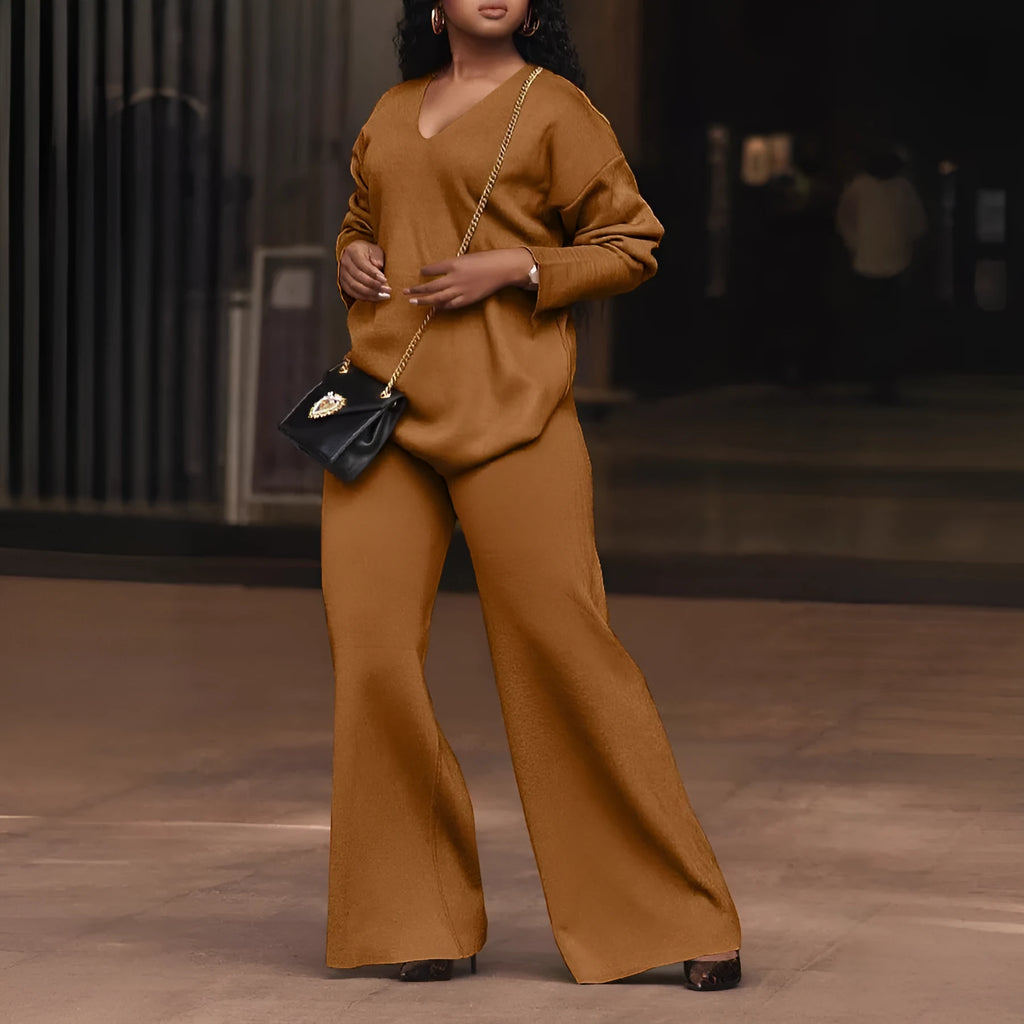 Brown women's suede two-piece suit with split sleeves and matching trousers on a hanger.